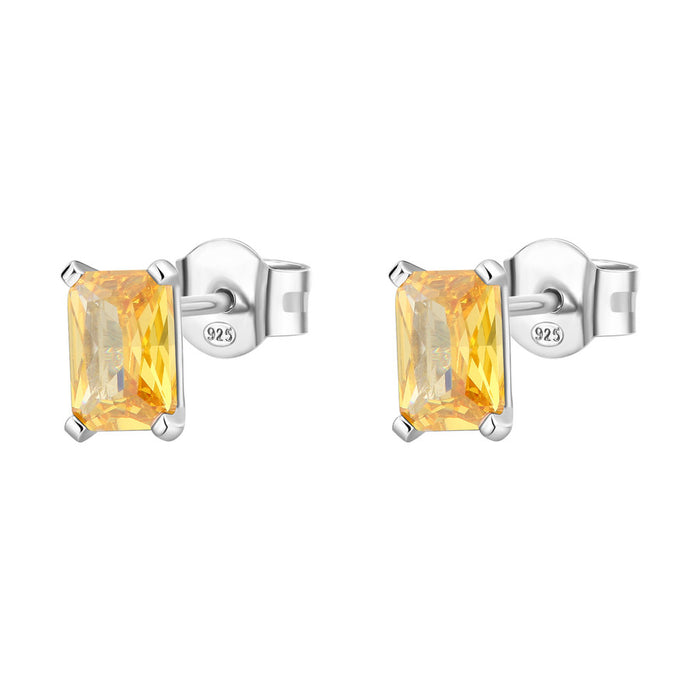 Pair of silver earrings with yellow gemstones on a white background