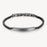Silver bracelet with a black beaded band on a white background