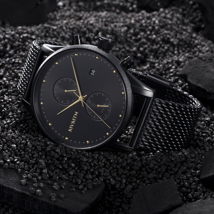Men's MVMT Voyager Tundra, accented with gold markers, hour, minute and second hands on a balck dial. Dual chronographs with active time keeping features and a date wheel placed at the three o'clock marker. This watch casing sits between a black mesh stainless steel strap perfect for intricate sizing. 