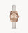 This piece features a slim white leather strap and a rose gold case and bezel. The crystal lined bezel frames the rose gold face with matching rose gold tone hour markers and hands. The day date is displayed at the 3 o'clock mark.