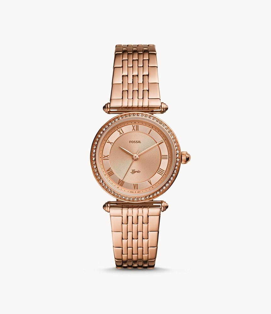 Rose gold-tone stainless steel case and bracelet. Fixed rose gold-tone bezel set with crystals. Rose dial with rose gold-tone hands and Roman numeral hour markers. Minute markers around the outer rim.