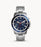 The silver tone stainless steel bracelet attaches to the stainless steel case that is also silver tone with a navy blue dial outside of the face. The face is also a metallic navy blue with whitie Roman numerals at each hour and 3 subtle subdials. The white hands match the numerals and provide the contrast necessary for easy readability.