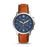 This watch features a reddish brown smooth leather strap with burnt edges that attaches to a modern, clean stainless steel case with a matte blue face. The juxtaposition of the two aesthetics draws attention and creates versatility for the piece. The gold and white accents on the face are easily visible.